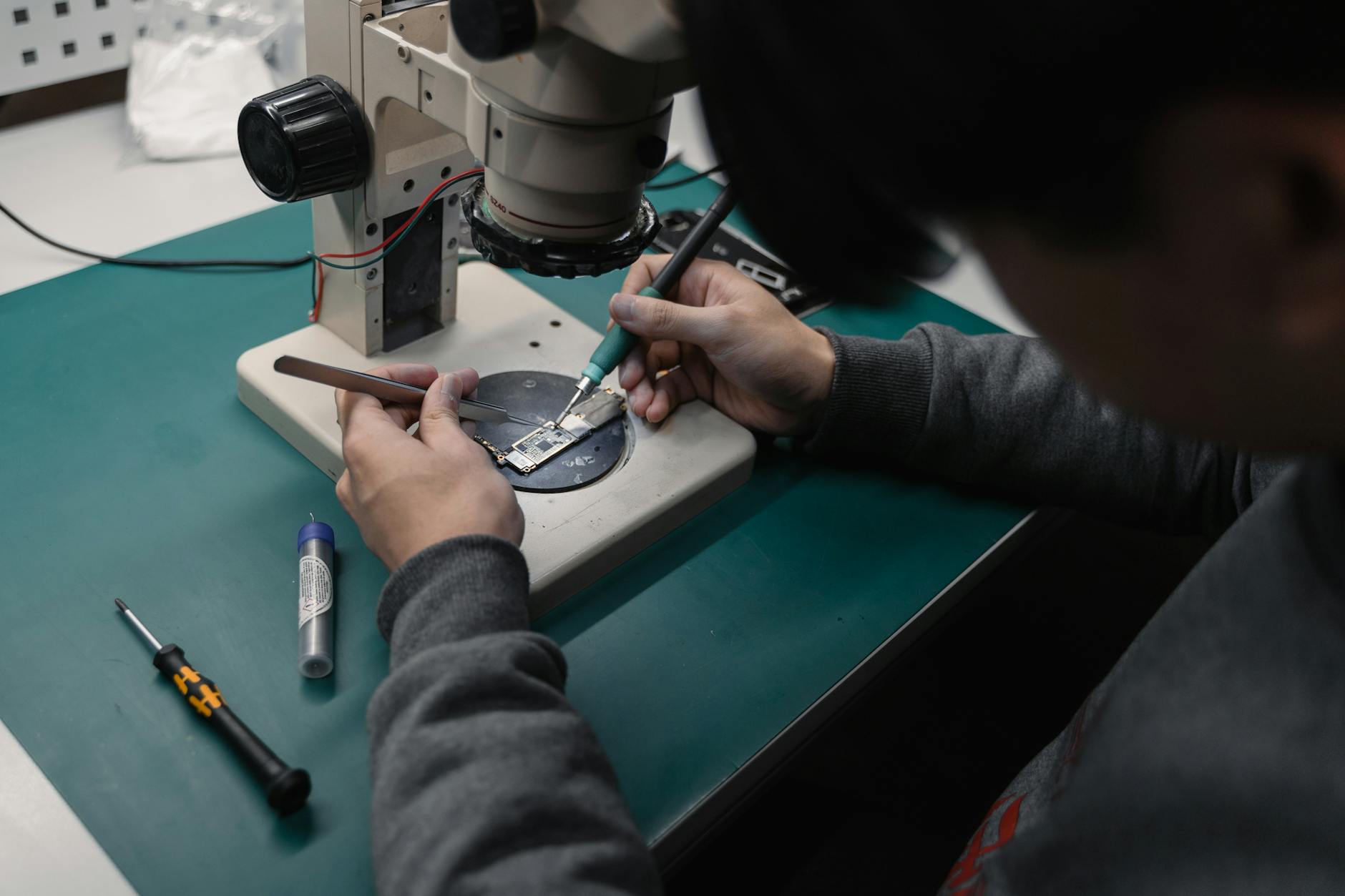 a person repairing the board on the microscope